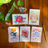 May include: A set of ten greeting cards with colorful floral and butterfly illustrations. The cards feature positive messages such as "Stay true to yourself", "Do it for your future self", "Listen to your heart", "You deserve great things", and "Imperfection is beautiful".
