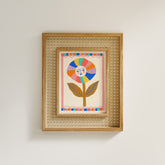 Framed artwork with a colorful flower design on a plain wall